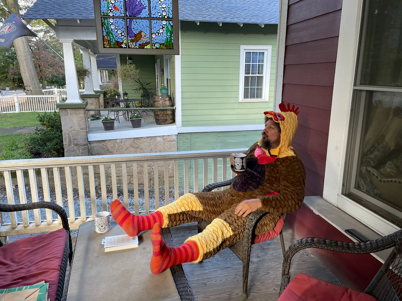 James DiStefano in a chicken costume, drinking coffee on his front porch